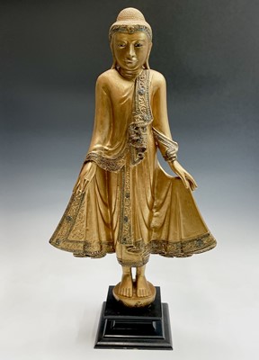 Lot 1041 - A Thai carved giltwood and jewelled standing...