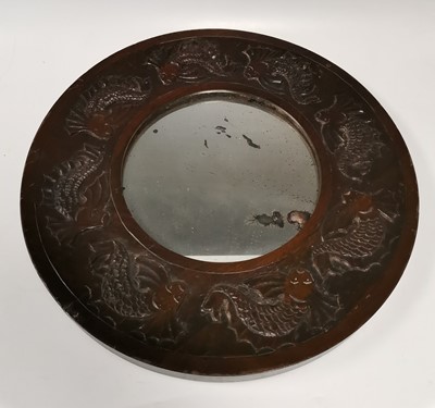 Lot 17 - A carved oak framed circular mirror, decorated...