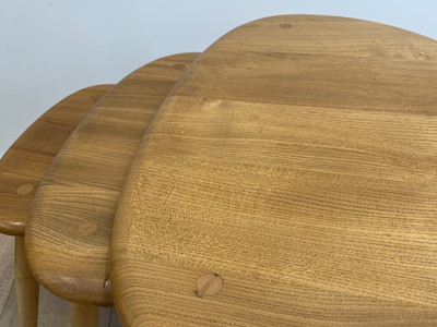 Lot 289 - An Ercol pale elm pebble nest of three tables,...