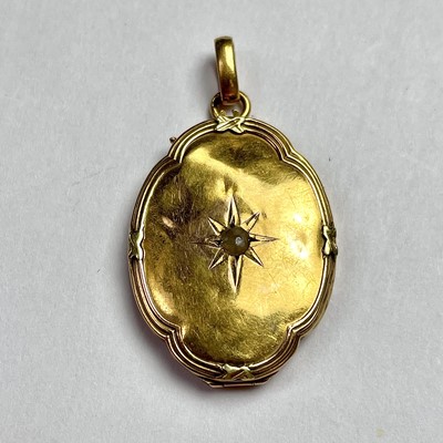Lot 615 - A gold and oval lobed pendant locket, the...