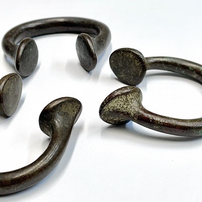 Lot 48 - Three bronze Manilla slave bangles.