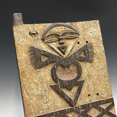 Lot 77 - An African wood carved panel of a stylised...