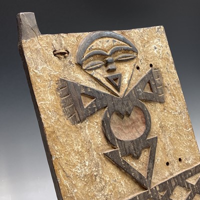 Lot 77 - An African wood carved panel of a stylised...