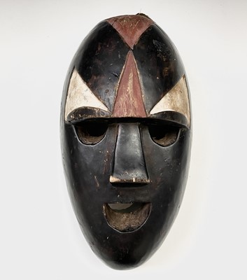 Lot 76 - An African tribal mask decorated with a simple...