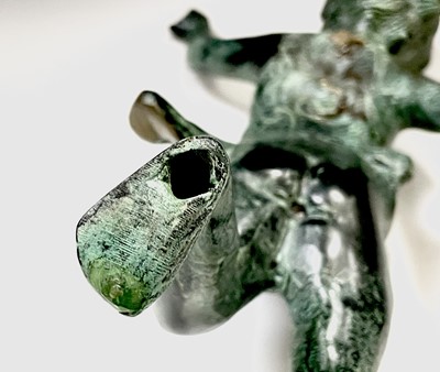 Lot 113 - A cast metal figure of putto indistinctly...