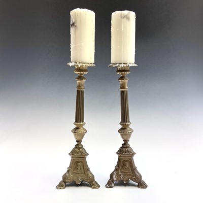 Lot 168 - A pair of brass candlesticks the tripod bases...