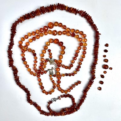 Lot 913 - An amber facet cut graduated bead triple...