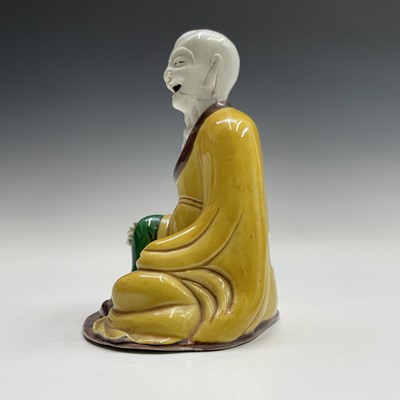 Lot 59 - A Chinese sancai-glazed figure of a seated...