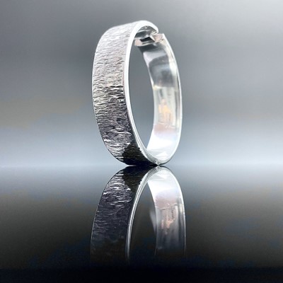 Lot 864 - A 1970's hallmarked silver hinged bangle with...