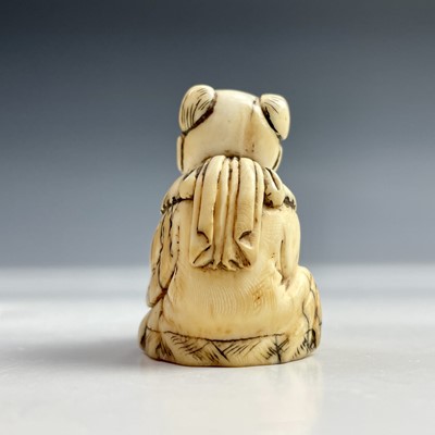 Lot 155 - A Japanese ivory netsuke of a seated man with...