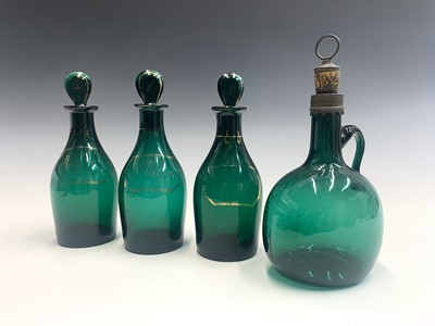 Lot 1018 - A set of three Regency green glass decanters...