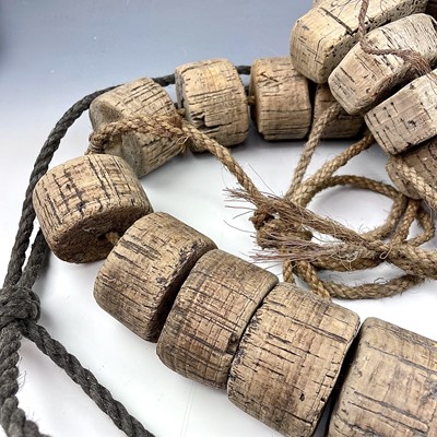 Lot 153 - Two strings of cork floats and stoneware end...