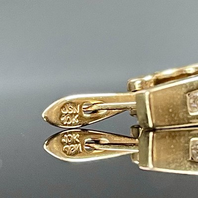 Lot 767 - A pair of 10k gold diamond channel set...
