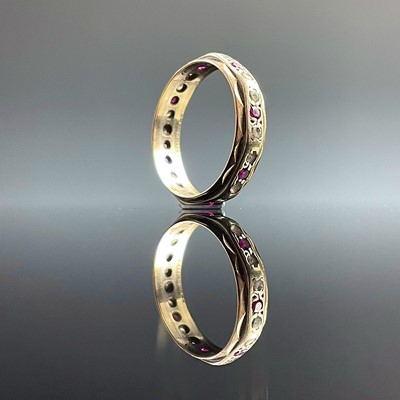 Lot 817 - A 9ct bi-colour gold eternity ring set with...