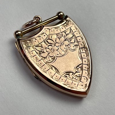 Lot 613 - A 9ct gold shield shaped foliate engraved...