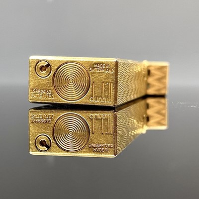 Lot 214 - A Dunhill gold plated engine turned lighter.