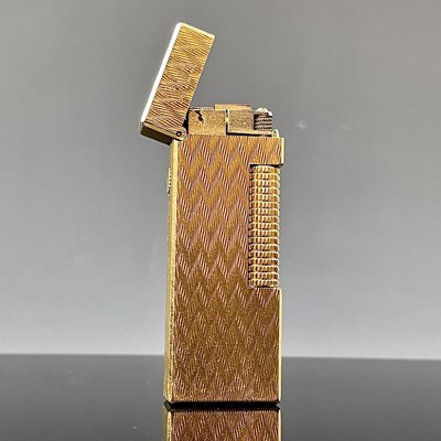 Lot 214 - A Dunhill gold plated engine turned lighter.