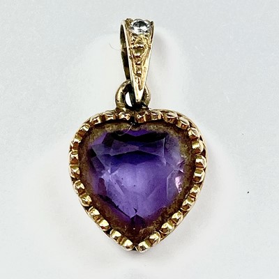 Lot 605 - A gold and amethyst heart shaped pendant, the...