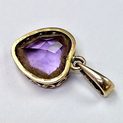Lot 605 - A gold and amethyst heart shaped pendant, the...