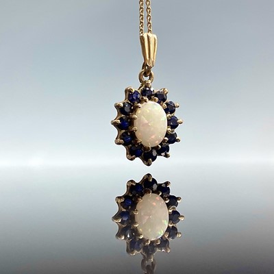 Lot 672 - A 9ct opal and sapphire cluster pendant...