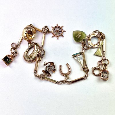 Lot 800 - A 9ct gold charm bracelet with 11 9ct gold...