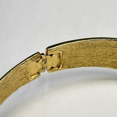 Lot 279 - An Alexis Kirk gilt metal and black enamel hinged choker.