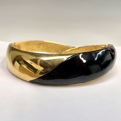 Lot 279 - An Alexis Kirk gilt metal and black enamel hinged choker.