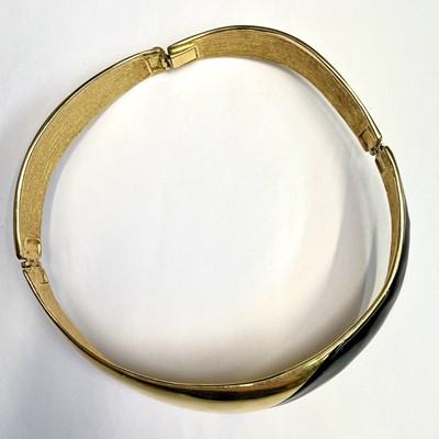 Lot 279 - An Alexis Kirk gilt metal and black enamel hinged choker.