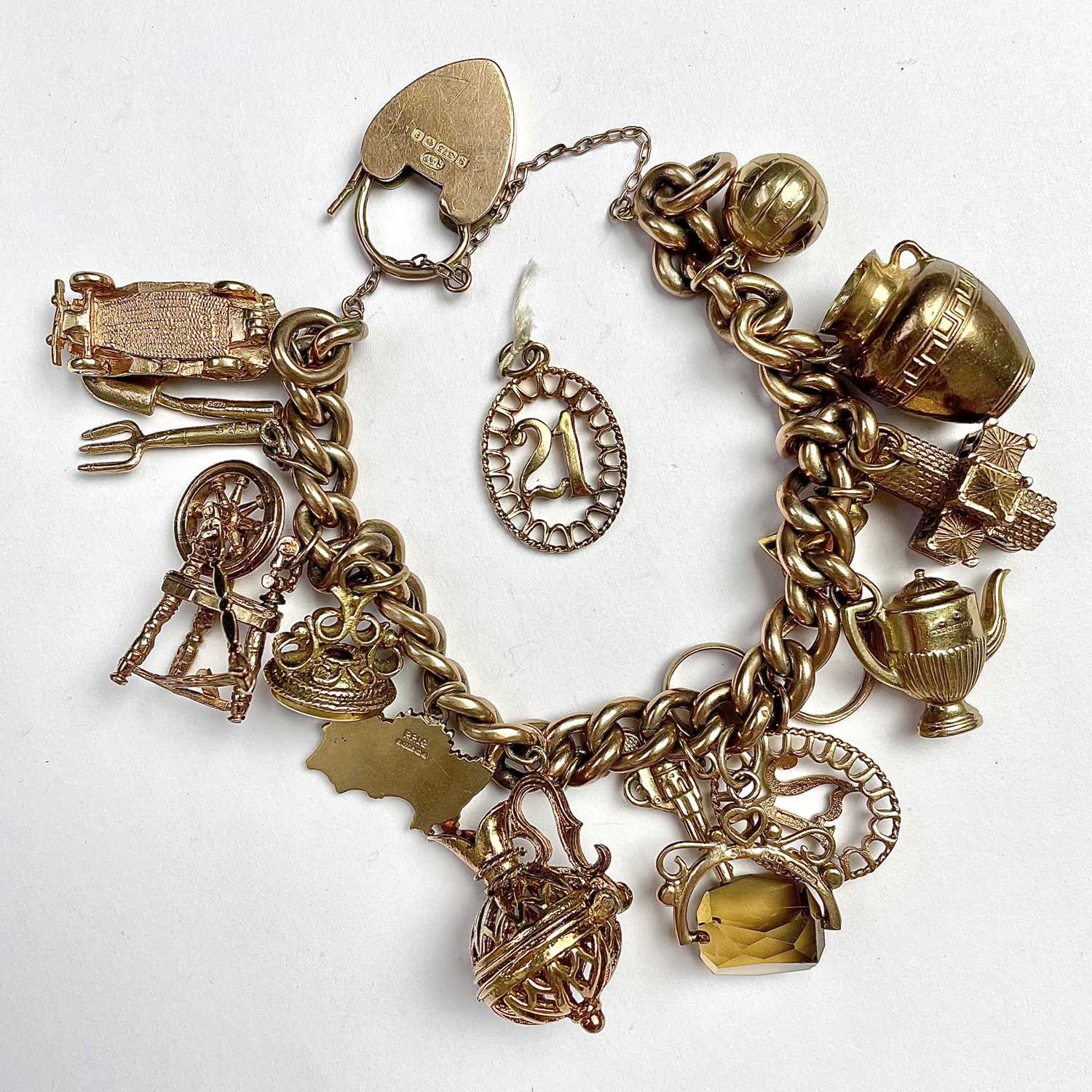 Lot 755 - A 9ct gold charm bracelet with 18 various...