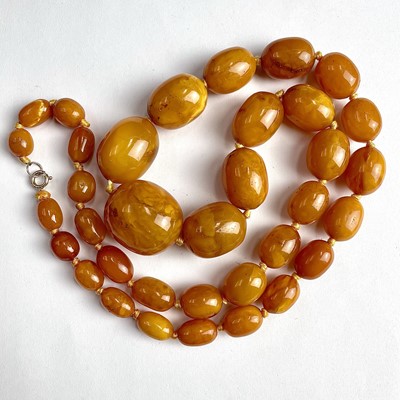Lot 685 - A butterscotch amber graduated oval bead...