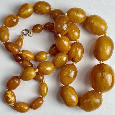 Lot 685 - A butterscotch amber graduated oval bead...