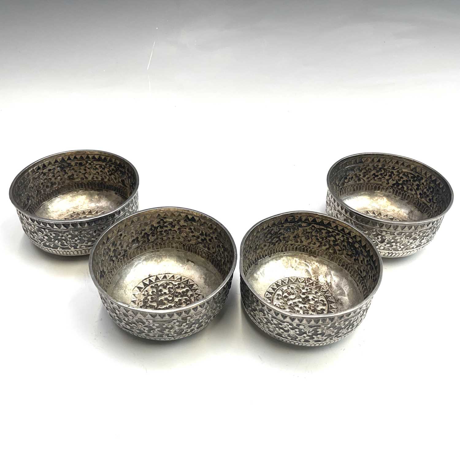 Lot 1052 - A set of four Indian white metal bowls, each...