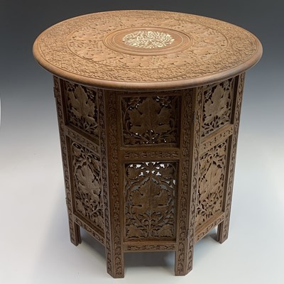 Lot 1054 - An Indian carved wood folding occasional table,...