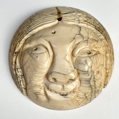 Lot 550 - A Japanese netsuke portraying a smiling Okame...