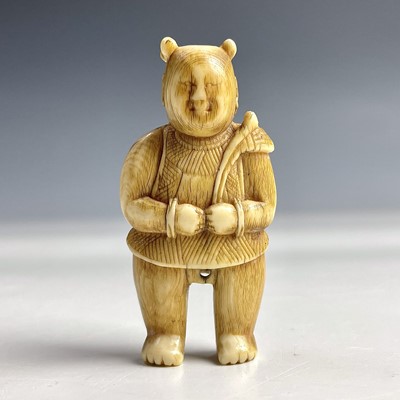 Lot 552 - A Japanese ivory netsuke of a standing figure...