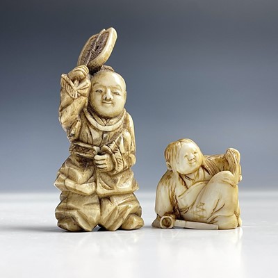 Lot 560 - A small Japanese ivory netsuke of a seated boy,...