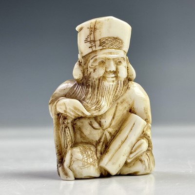 Lot 562 - A Japanese ivory netsuke of a seated bearded...