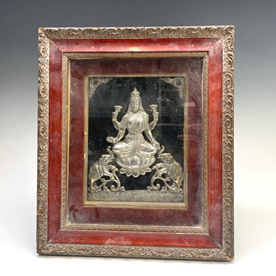 Lot 1059 - An Indian white metal seated goddess flanked...