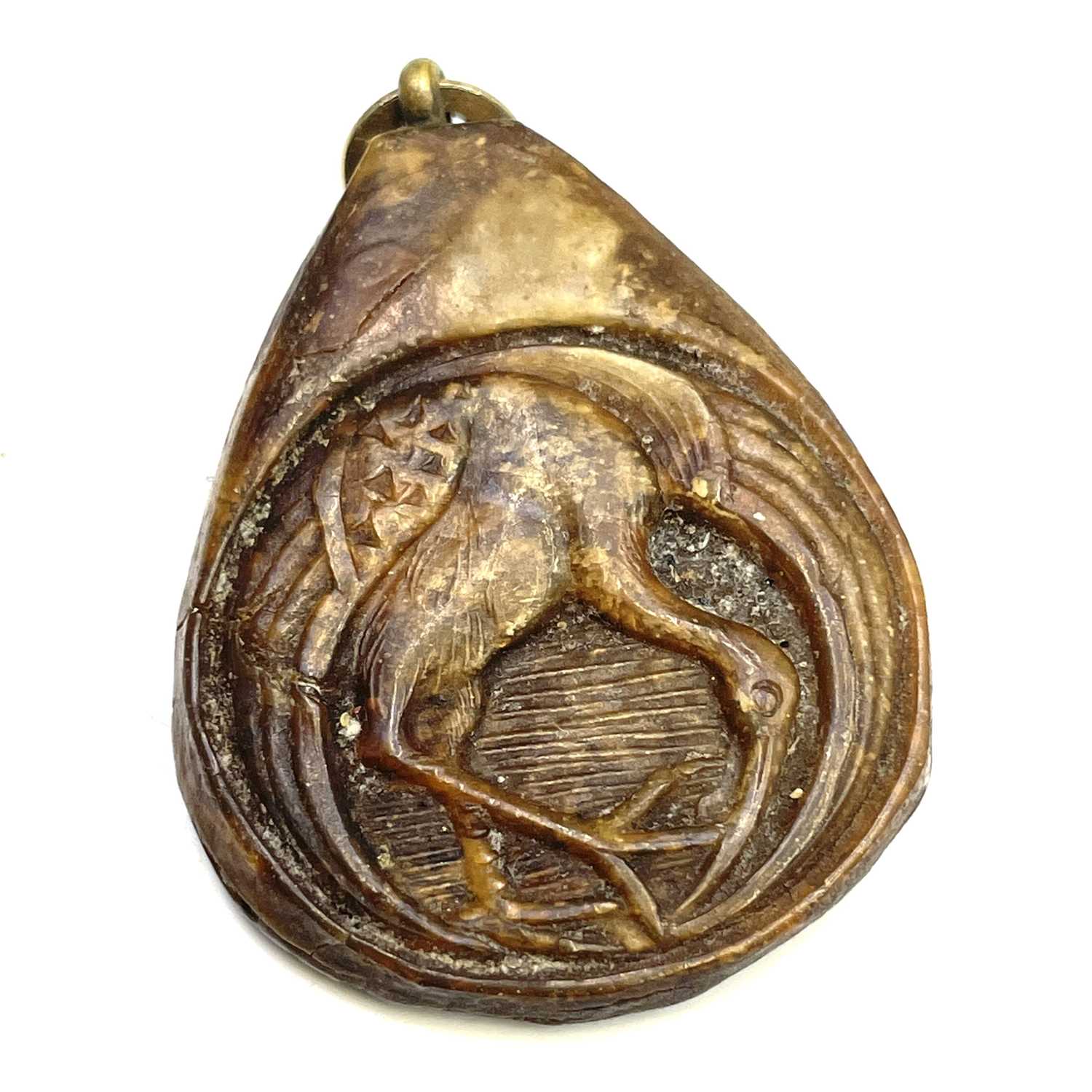 Lot 580 - A Japanese carved horn pendant, the front...