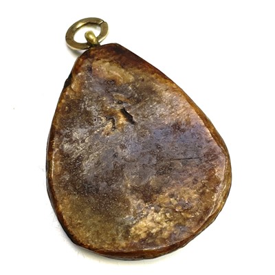 Lot 580 - A Japanese carved horn pendant, the front...