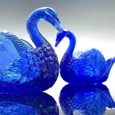 Lot 911 - Two Burtles, Tate & Co blue glass swan salts,...