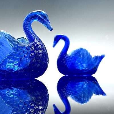 Lot 911 - Two Burtles, Tate & Co blue glass swan salts,...
