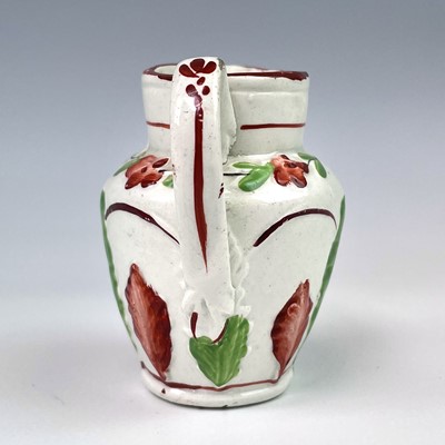 Lot 246 - A small creamware jug, circa 1820, moulded...