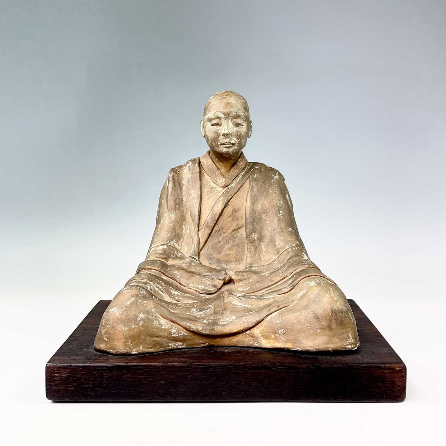 Lot 191 - A painted model of a seated Buddhist monk on a...