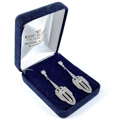 Lot 41 - A pair of Art Deco style white metal white stone set pendant stud earrings.