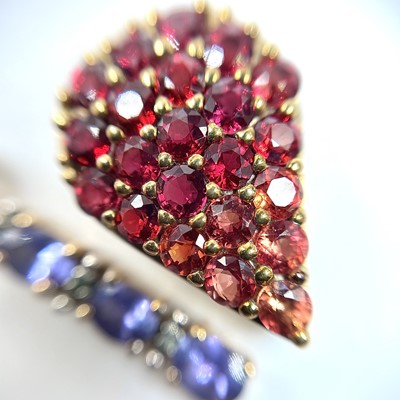 Lot 75 - A 9ct gold red and orange sapphire graduated...