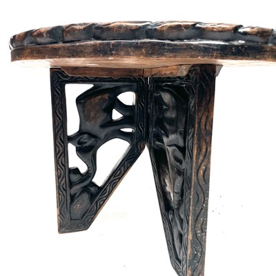 Lot 220 - An African wood carved circular folding table...