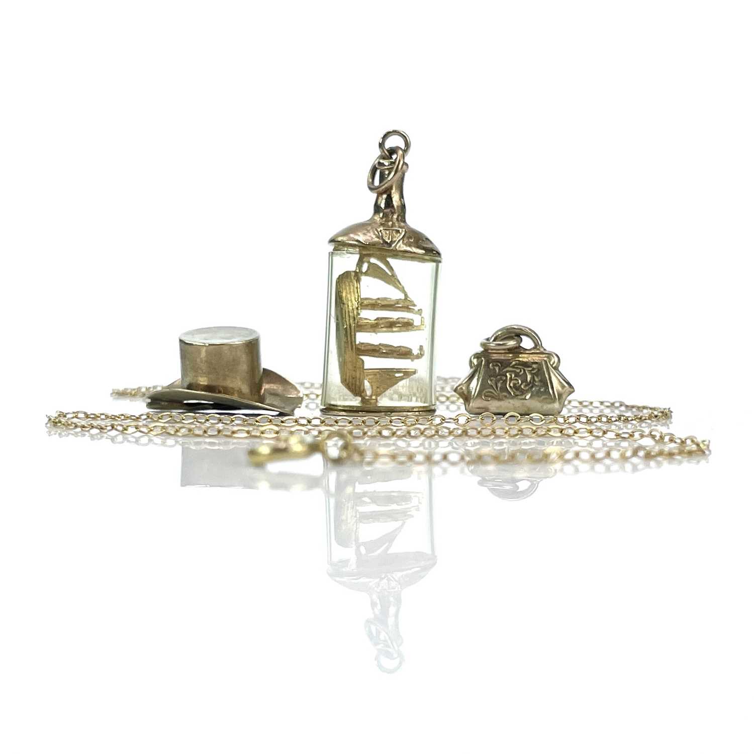 Lot 119 - A 9ct hallmarked gold ship in a bottle charm,...