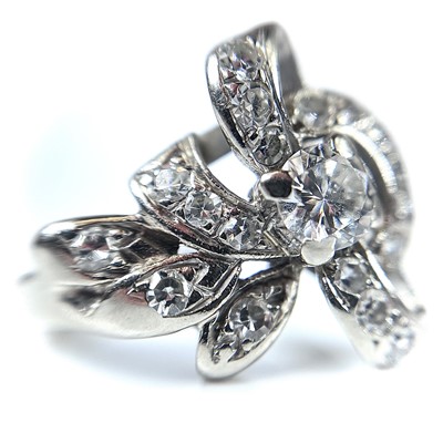 Lot 110 - A 14k white gold diamond dress ring of floral...