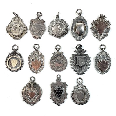 Lot 251 - A collection of thirteen silver shield fobs,...
